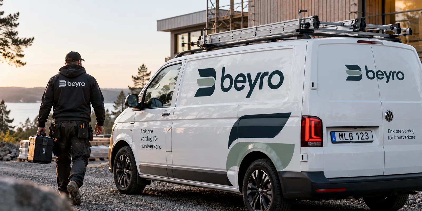 Hantverkare på väg mot en servicebil med Beyros dekor, vid ett pågående husbygge.